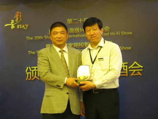 中国音响协会秘书长陈立新先生向昆河音响总经理梅弘夫先生颁奖 
